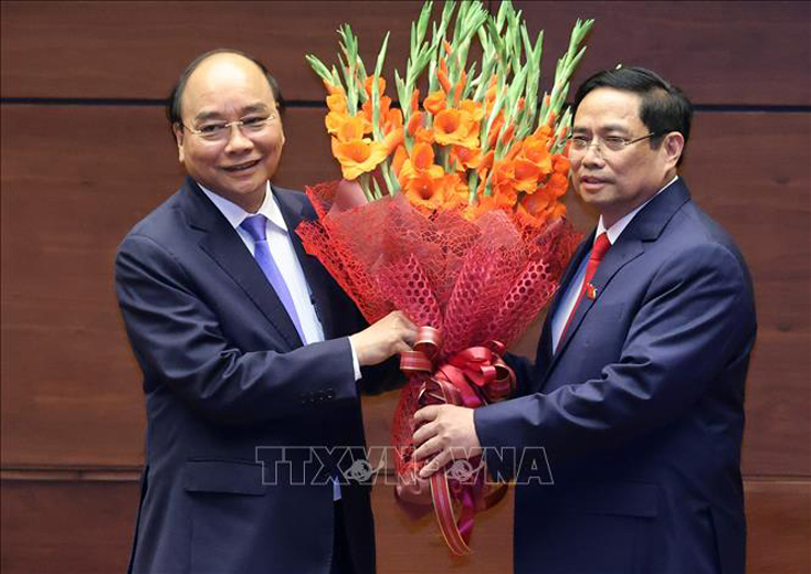 Thủ tướng Phạm Minh Chính tặng hoa Chủ tịch nước Nguyễn Xuân Phúc, Thủ tướng Chính phủ nhiệm kỳ 2016 - 2021. Ảnh: Thống Nhất/TTXVN 