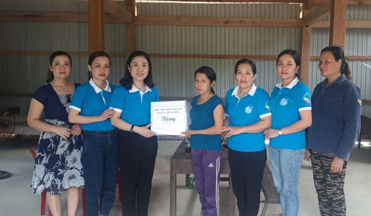 Đại diện Hội LHPN huyện Minh Hóa tặng quà cho chị Đinh Thị Cánh.