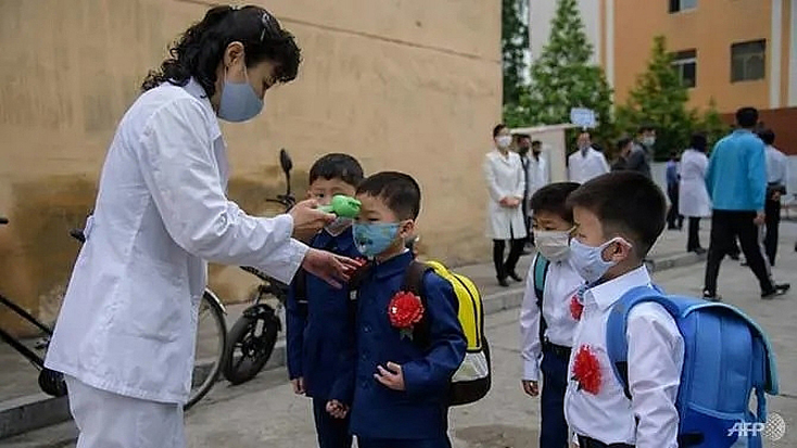 Trẻ em tại Bình Nhưỡng được đo thân nhiệt khi tới trường. Ảnh: AFP 
