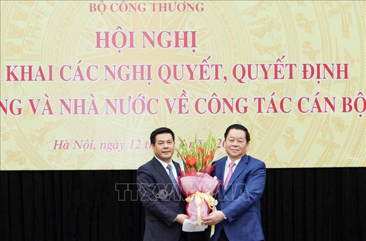 Bí thư Trung ương Đảng, Trưởng ban Tuyên giáo Trung ương Nguyễn Trọng Nghĩa (bên phải) tặng hoa chúc mừng tân Bộ trưởng Bộ Công Thương Nguyễn Hồng Diên. Ảnh: Trần Việt/TTXVN