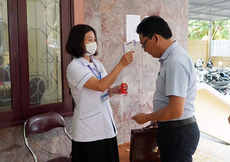 Cán bộ tham gia buổi tiếp và đối thoại với dân được đo thân nhiệt và thực hiện các biện pháp phòng chống dịch bệnh Covid-19.