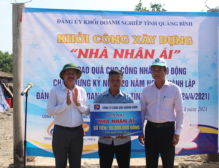 Đồng chí Trần Quốc Tuấn, Bí thư Đảng ủy Khối Doanh nghiệp tỉnh và đồng chí Lê Anh Hùng, Bí thư Đảng ủy Công ty xăng dầu Quảng Bình trao biển tượng trưng hỗ trợ tiền xây nhà cho gia đình anh Trương Văn Duy.