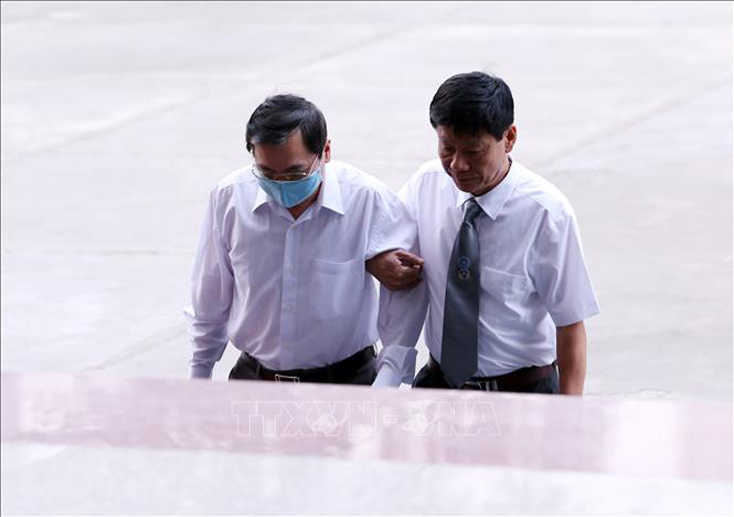 Bị cáo Vũ Huy Hoàng (bên trái) đến tòa.