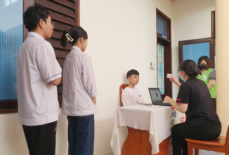 Cán bộ coi thi tiến hành kiểm tra nghiêm ngặt đối với thí sinh thi chứng chỉ IELTS quốc tế trước khi vào phòng thi.
