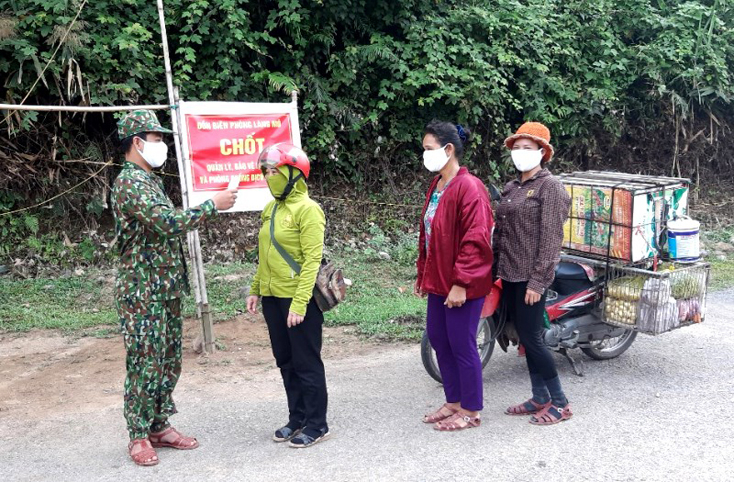 Cán bộ chốt kiểm soát đồn Biên phòng Làng Mô cấp đo thân nhiệt và tuyên truyền phòng chống dịch Covid-19 cho người dân ra, vào khu vực địa bàn . 