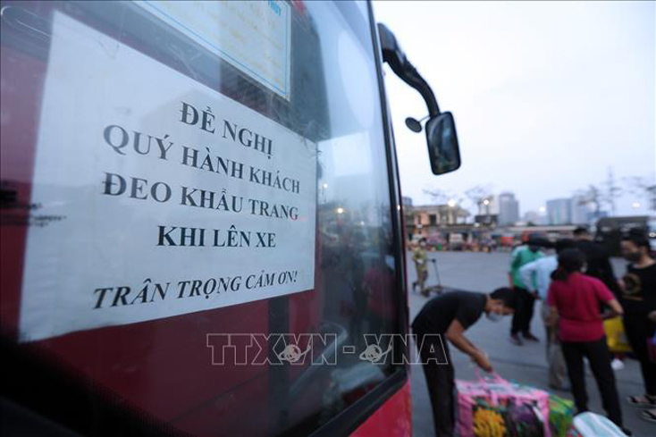 Bản thông báo yêu cầu hành khách phải đeo khẩu trang trước khi lên xe. Ảnh: TTXVN.
