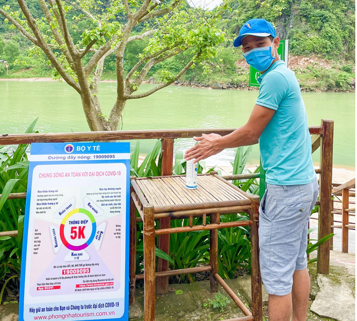 Du khách thực hiện các biện pháp khử khuẩn để phòng, chống dịch Covid-19 khi đến Phong Nha-Kẻ Bàng.