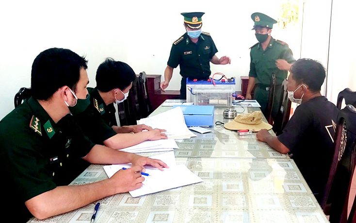Cán bộ, chiến sĩ đồn Biên phòng Nhật Lệ, BĐBP Quảng Bình tịch thu tang vật và tiến hành lấy lời khai đối tượng Võ Đức Dỹ.