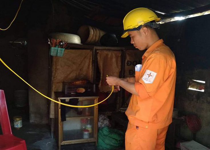 Công nhân Điện lực Lệ Thủy đang sửa chữa lại điện trong nhà cho khách hàng