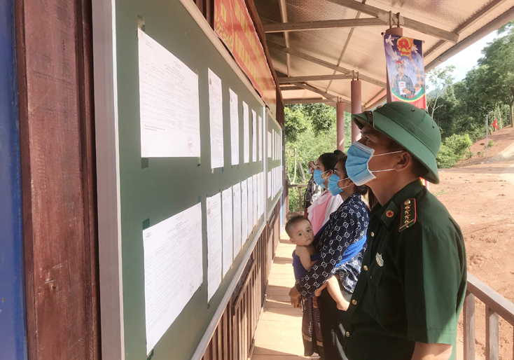 Cán bộ, chiến sỹ Đồn Biên phòng Cà Roòng và cử tri xã Thượng Trạch (Bố Trạch) xem tiểu sử các ứng cử viên ĐBQH và đại biểu HĐND các cấp, nhiệm kỳ 2021-2026.