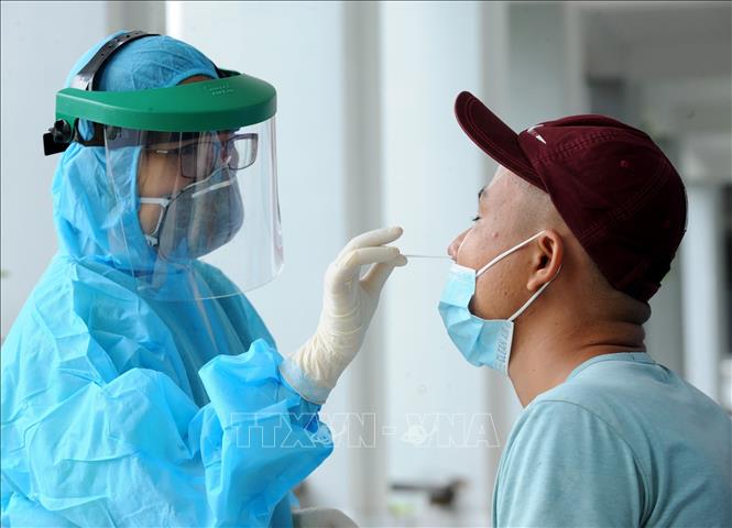 Lấy mẫu xét nghiệm SARS-CoV-2 cho người dân khu vực có nguy cơ. Ảnh: TTXVN