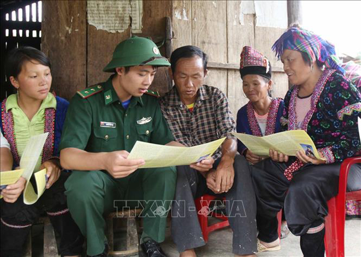 Cán bộ chiến sĩ Đồn Biên phòng Pa Tần, huyện Phong Thổ (Lai Châu) xuống bản Pho 2, xã Pa Tần phát tờ rơi và tuyền truyền tới người dân về tác hại của ma túy. Ảnh: Quý Trung/TTXVN