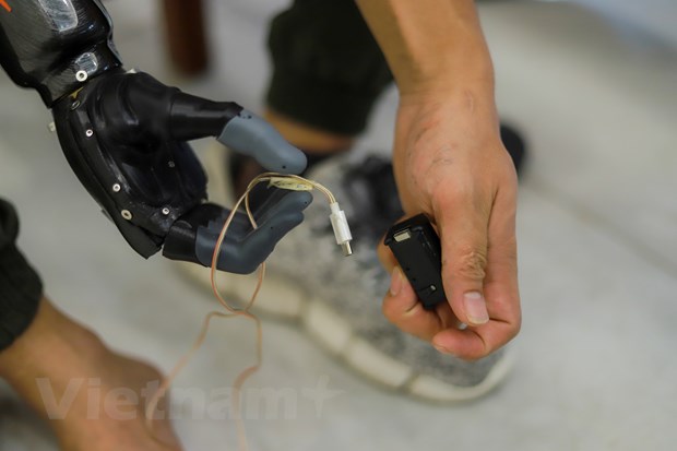 Cánh tay được sạc và điều khiển hoàn toàn bằng cử động chân. (Ảnh: Minh Sơn/Vietnam+)