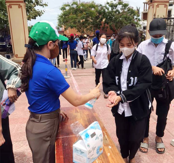 Lực lượng đoàn viên hướng dẫn các thí sinh khử khuẩn tay
