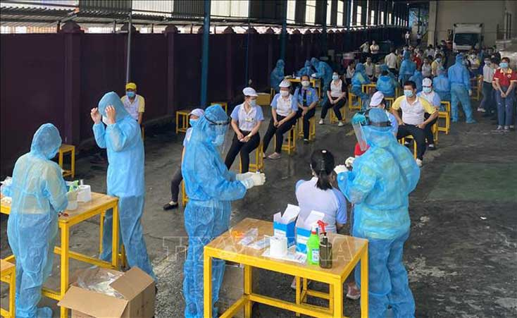 Các y, bác sỹ Trung tâm kiểm soát bệnh tật TP Hồ Chí Minh và Quận 7 thực hiện xét nghiệm sàng lọc COVID-19 ngẫu nhiên cho công nhân Công ty TNHH Solen Việt Nam ở Khu chế xuất Tân Thuận ngày 3-6. Ảnh minh họa: Thanh Vũ/TTXVN