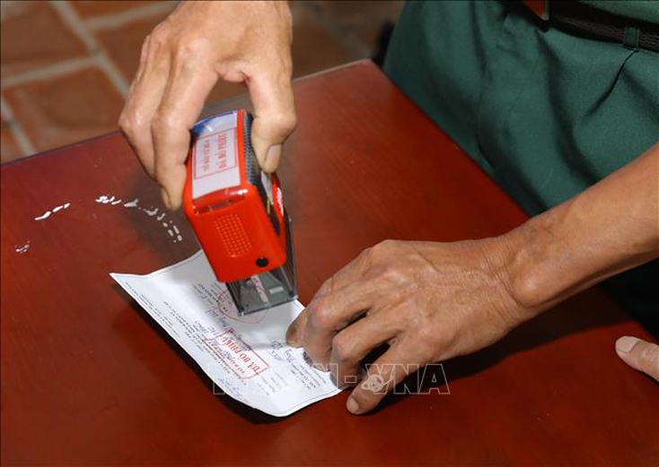 Đóng dấu xác nhận đã bầu cử tại Khu vực bỏ phiếu số 04, xã Tráng Việt, huyện Mê Linh, TP Hà Nội. Ảnh: Nguyễn Điệp/TTXVN