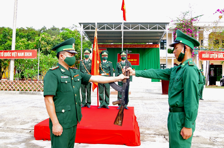 Chỉ huy Tiểu đoàn Huấn luyện-Cơ động, BĐBP tỉnh thực hiện nghi thức trao súng cho chiến sĩ mới.