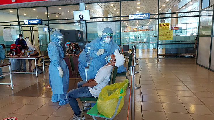 LCán bộ y tế lấy mẫu xét nghiệm SARS-CoV-2 ngẫu nhiên đối với hành khách.