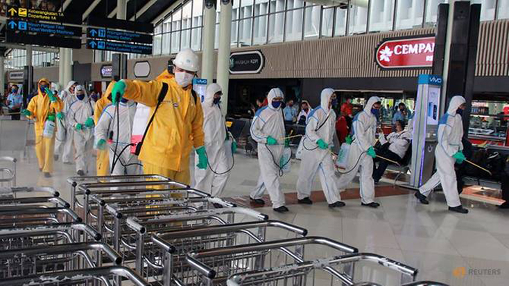 Nhân viên khử trùng làm nhiệm vụ tại sân bay quốc tế Soekarno-Hatta gần Jakarta, Indonesia. Ảnh: Reuters