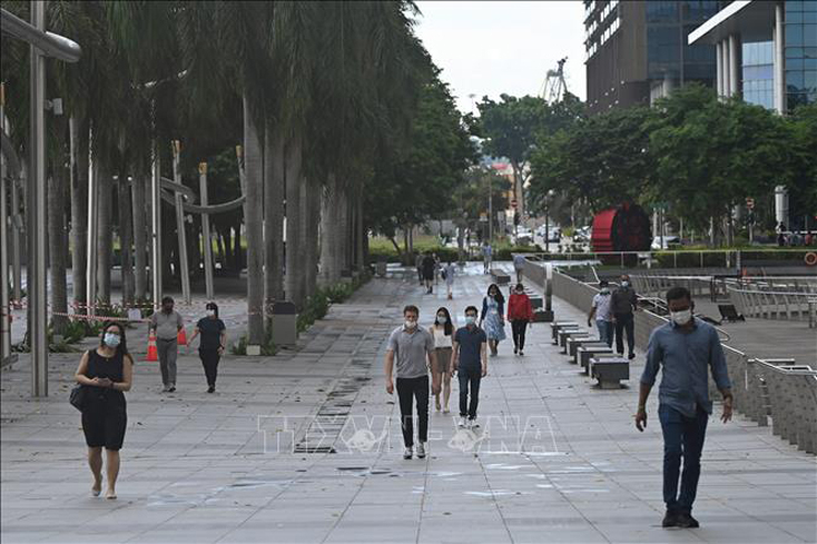 Người dân đeo khẩu trang phòng dịch COVID-19 tại Vịnh Marina, Singapore, ngày 14-5-2021. Ảnh: AFP/ TTXVN