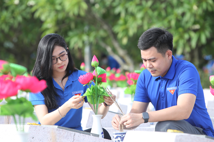 Các đoàn viên, thanh niên làm vệ sinh, thay hoa tại Nghĩa trang Liệt sĩ Ba Dốc. 