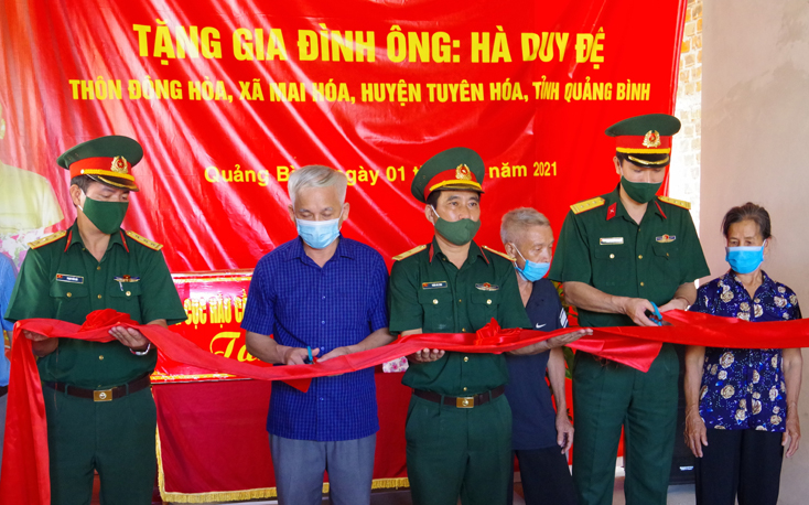 Đại diện Bộ CHQS tỉnh, Ban CHQS huyện Tuyên Hóa và chính quyền địa phương làm lễ cắt băng khánh thành nhà tình nghĩa cho ông Hà Văn Đệ. 