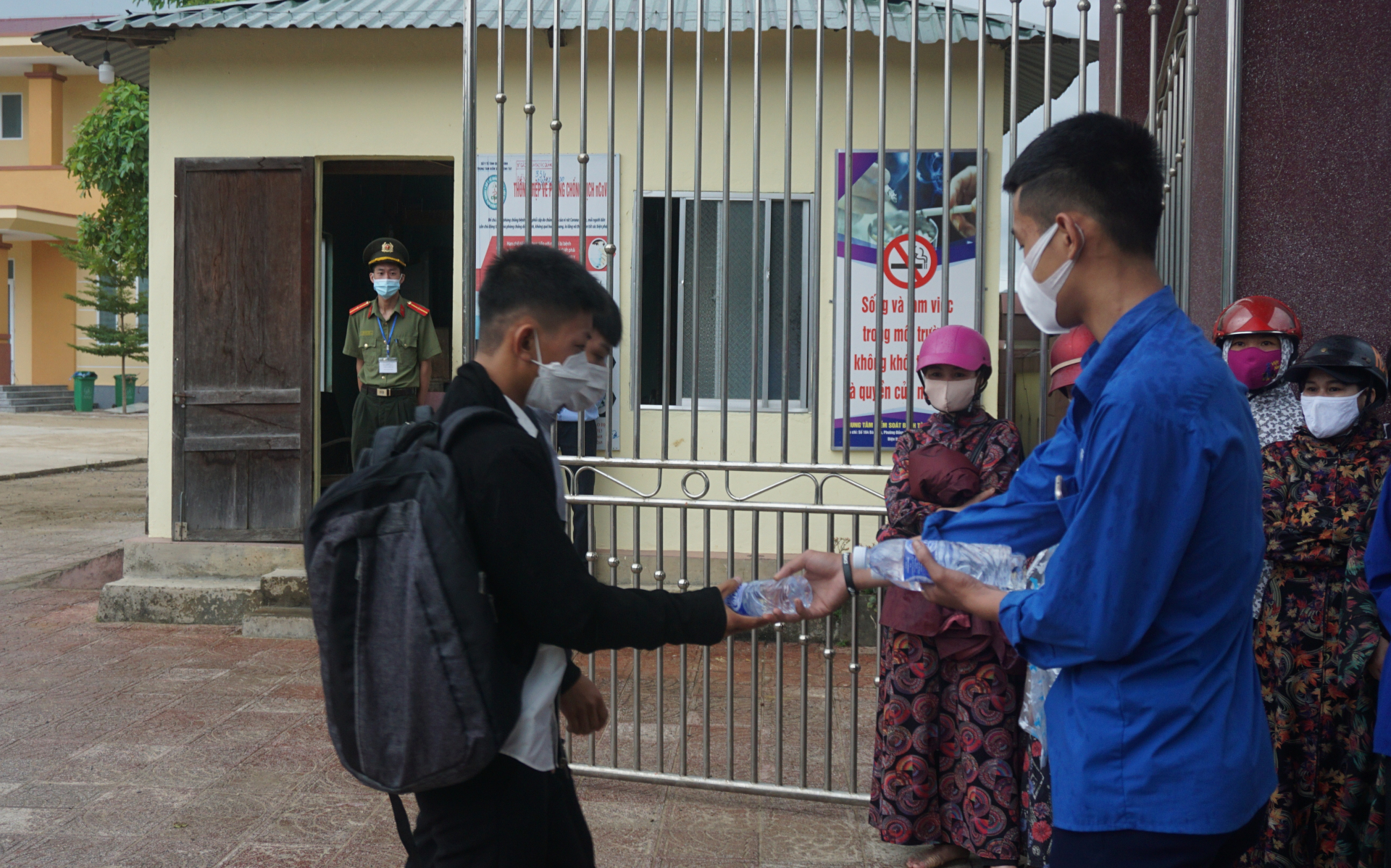Thanh niên tình nguyện phát nước uống và khẩu trang cho thí sinh.
