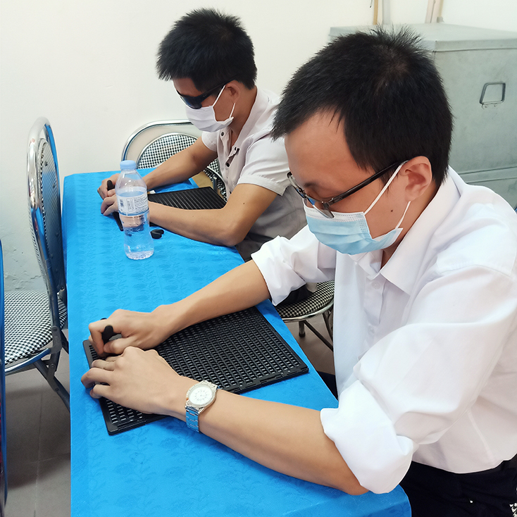 Các thí sinh khiếm thị đang thực hiện phần thi viết chữ Braille