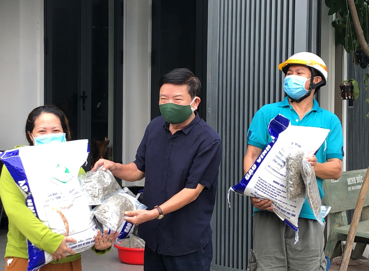 Ông Nguyễn Văn Dưỡng, Chủ tịch BCH Hội đồng hương huyện Quảng Ninh tại TP.HCM, trao gạo và cá khô cho bà con đồng hương gặp khó khăn do dịch bệnh. Ảnh: AN NHIÊN