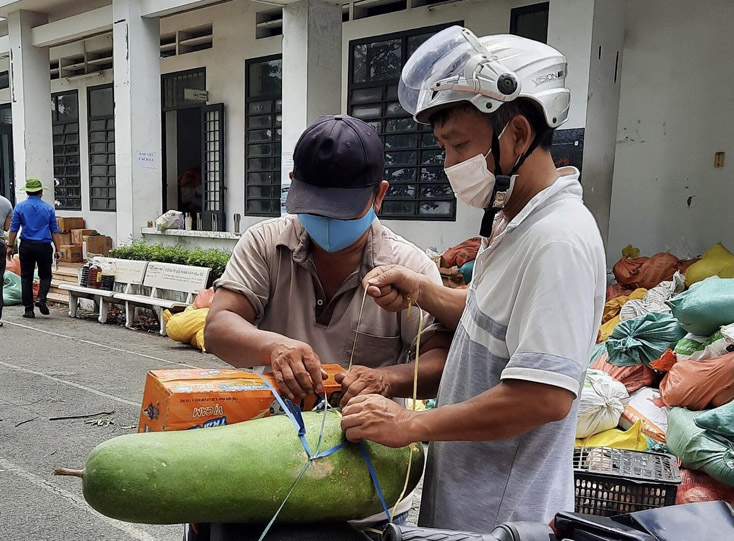 Người dân nhận gạo, bí xanh từ tấm lòng bà con quê hương Bố Trạch. Ảnh: HOÀI NAM