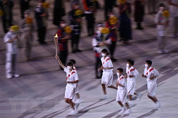 Các vận động viên rước đuốc Olympic tại lễ khai mạc Olympic Tokyo 2020 ở Tokyo, Nhật Bản, ngày 23-7. (Ảnh: AFP/TTXVN)