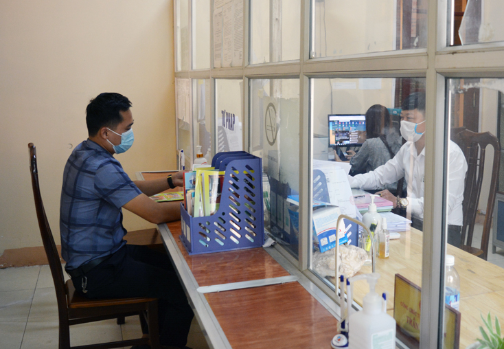 Cán bộ và người dân thực hiện giãn cách, tiếp dân theo thứ tự tại bộ phận giao dịch một cửa TT. Hoàn Lão.