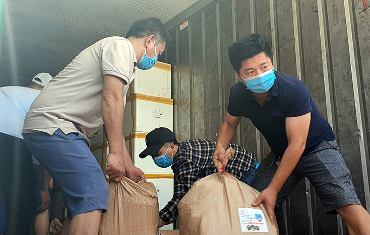 Anh Trần Anh Tuyến (áo đen), Chủ nhiệm CLB HDVDL Quảng Bình đang bốc xếp hàng hóa của bà con Quảng Bình sẻ chia gửi vào TP. Hồ Chí Minh.