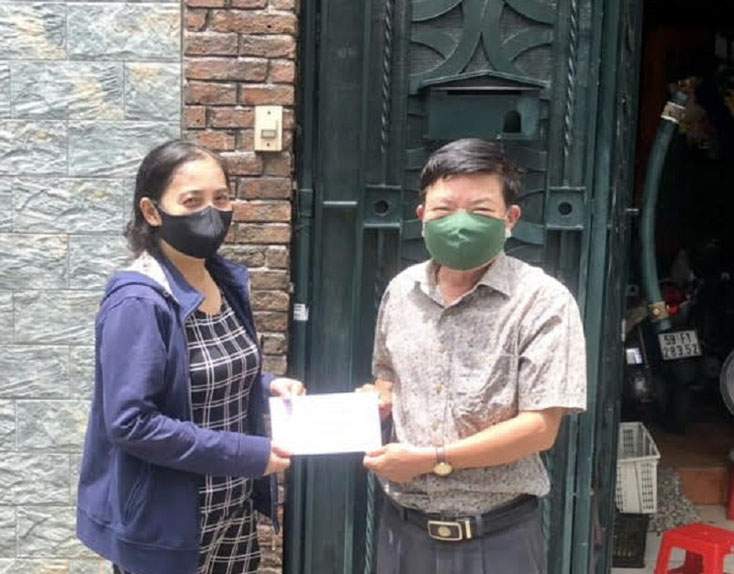 Ông Nguyễn Văn Dưỡng, Phó Chủ tịch HĐH tỉnh Quảng Bình tại TP.HCM trao quà cho gia đình anh Nguyễn Hữu Thường, tài xế taxi, ngụ tại quận 3. 