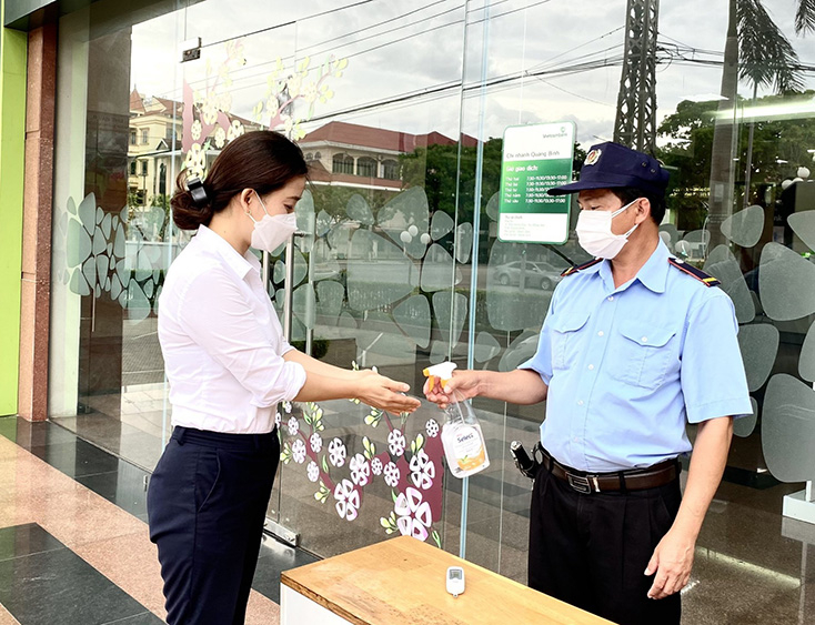 Khách hàng được sát khuẩn tay, đo thân nhiệt trước khi vào giao dịch tại các ngân hàng.