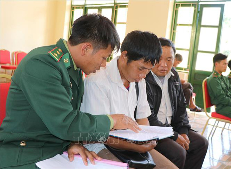  Chiến sĩ Đồn biên phòng Nậm Kè (Bộ đội Biên phòng tỉnh Điện Biên) trao đổi nội dung tuyên truyền, phổ biến pháp luật cho các trưởng bản. Ảnh: Xuân Tiến/TTXVN