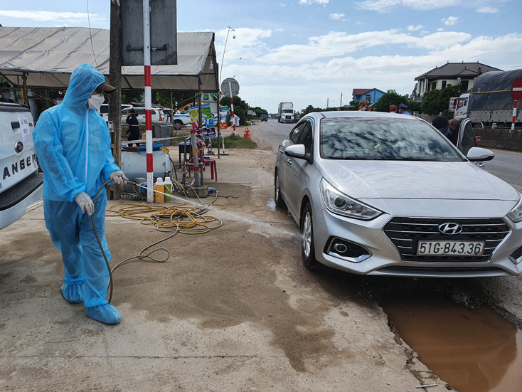 Lực lượng y tế của Trung tâm Y tế huyện Lệ Thủy đang phun tiêu độc, khử trùng cho phương tiện trở về từ vùng dịch
