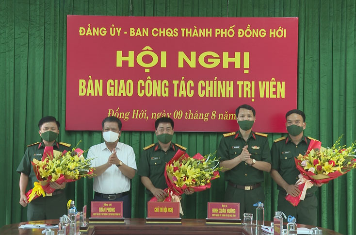 Đại diện Ban Thường vụ Thành ủy Đồng Hới và Đảng ủy Bộ CHQS tỉnh tặng hoa chúc mừng các đồng chí được bổ nhiệm và điều động công tác mới