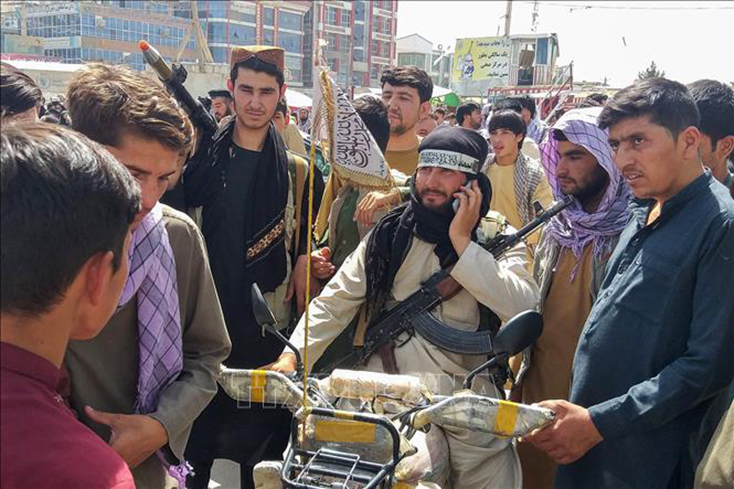 Các tay súng Taliban (giữa) tại Pul-e-Khumri ngày 11-8-2021, sau khi lực lượng Taliban chiếm được Pul-e-Khumri, thủ phủ tỉnh Baghlan, cách thủ đô Kabul, Afghanistan, khoảng 200km về phía bắc. Ảnh: AFP/TTXVN