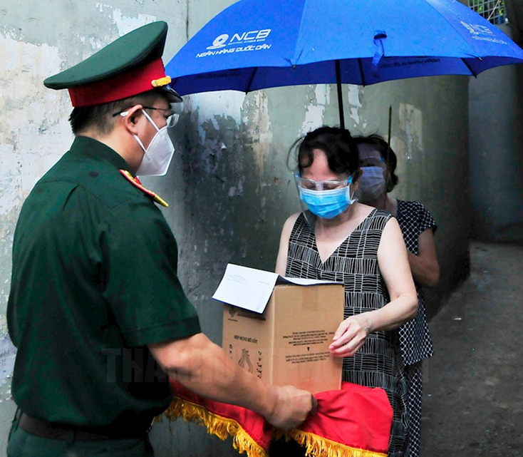 Thượng tá Phạm Viết Thanh, Chính trị viên Ban CHQS Quận 10 tận tay trao tro cốt nạn nhân tử vong do mắc Covid-19 cho gia đình.