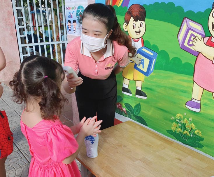 Các giáo viên của Trường mầm non tư thục trên địa bàn TP. Đồng Hới thực hiện đo thân nhiệt, sát khuẩn tay khi học sinh đi học trở lại.