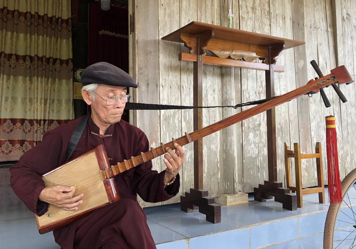 Nghệ nhân Đinh Văn Đống và chiếc đàn đáy mà ông vừa hoàn thành.