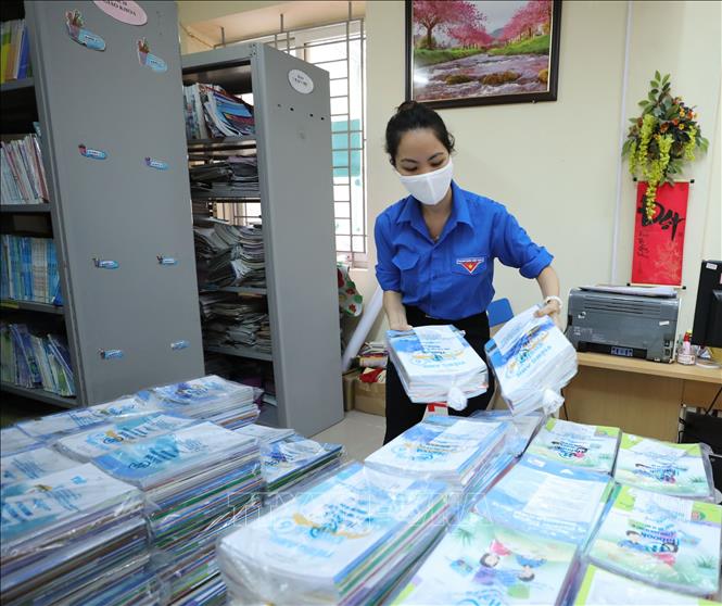 Giáo viên phụ trách công tác Đoàn Trường THCS Ngọc Lâm (quận Long Biên, Hà Nội) sắp xếp, phân loại sách giáo khoa để chuẩn bị chuyển tới học sinh. Ảnh: Thanh Tùng/TTXVN