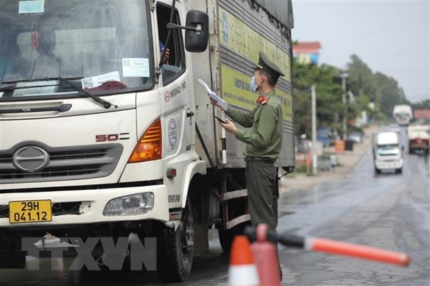 Lực lượng chức năng tại chốt kiểm soát đầu cầu Trung Hà (huyện Ba Vì, Hà Nội) kiểm tra giấy tờ của người và phương tiện khi qua chốt. (Ảnh: Minh Quyết/TTXVN)