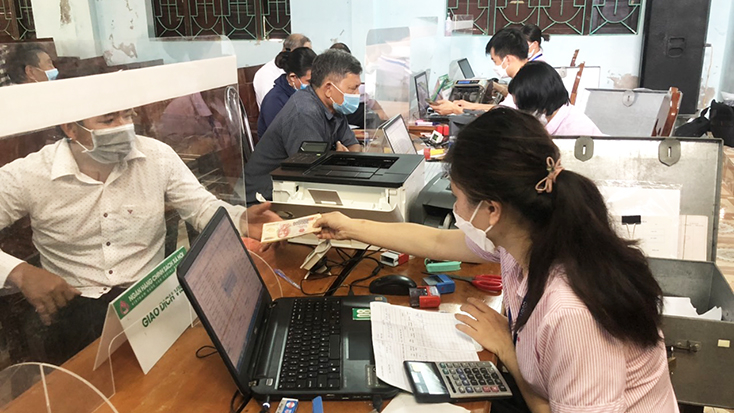 Cán bộ PGD NHCSXH TX. Ba Đồn làm thủ tục giải ngân vốn vay cho các đối tượng chính sách trên địa bàn.
