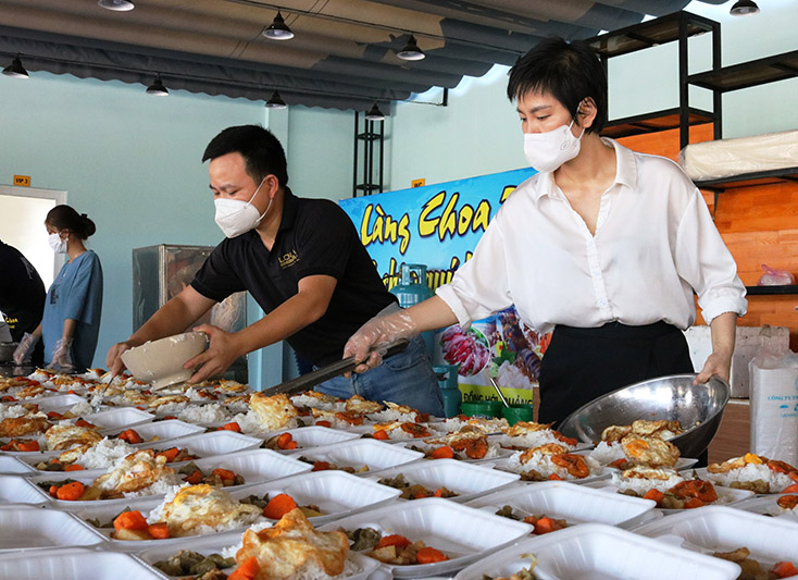 Vợ chồng chị Thơm anh Hà kiểm tra từng suất ăn trước khi đóng gói
