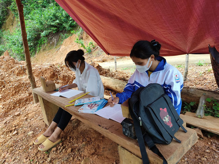 Hai chị em Son và Huyền đang học bài trong lán