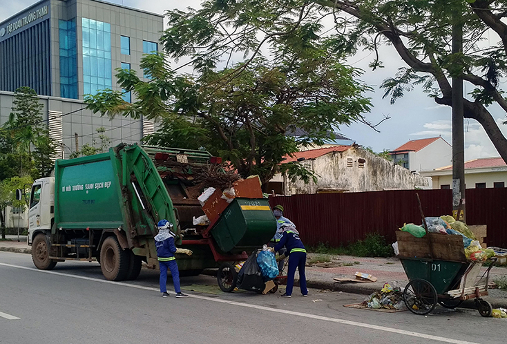 Tổ VSMT của chị Nguyễn Thị Tịch chuyển rác thu gom lên xe chuyên dụng, chuẩn bị kết thúc một ngày làm việc