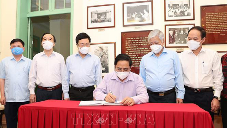 Thủ tướng Phạm Minh Chính ghi cảm tưởng vào Sổ lưu niệm trong Phòng truyền thống của Ủy ban Trung ương Mặt trận Tổ quốc Việt Nam. Ảnh: Dương Giang/TTXVN