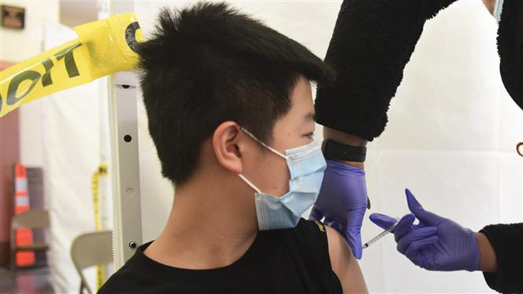 Nhân viên y tế tiêm vaccine ngừa COVID-19 cho trẻ em tại trường học ở Los Angeles, California, Mỹ. Ảnh: AFP/TTXVN